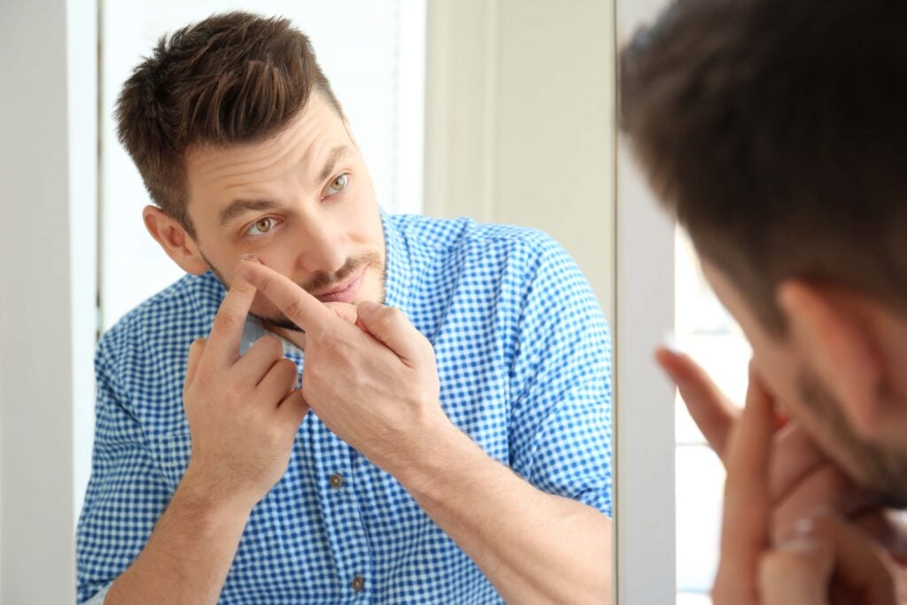 Person testing contact lenses in a mirror