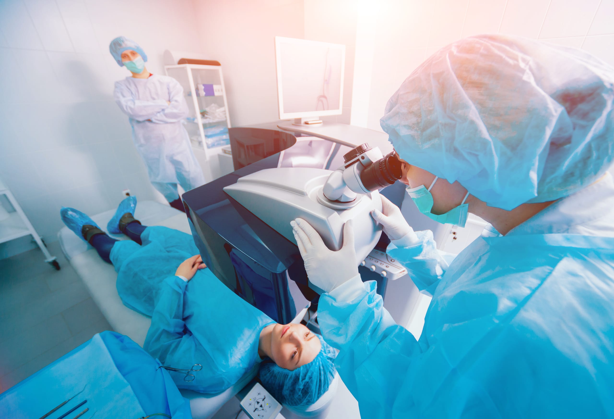 Patient and team of surgeons in operating room during lasik