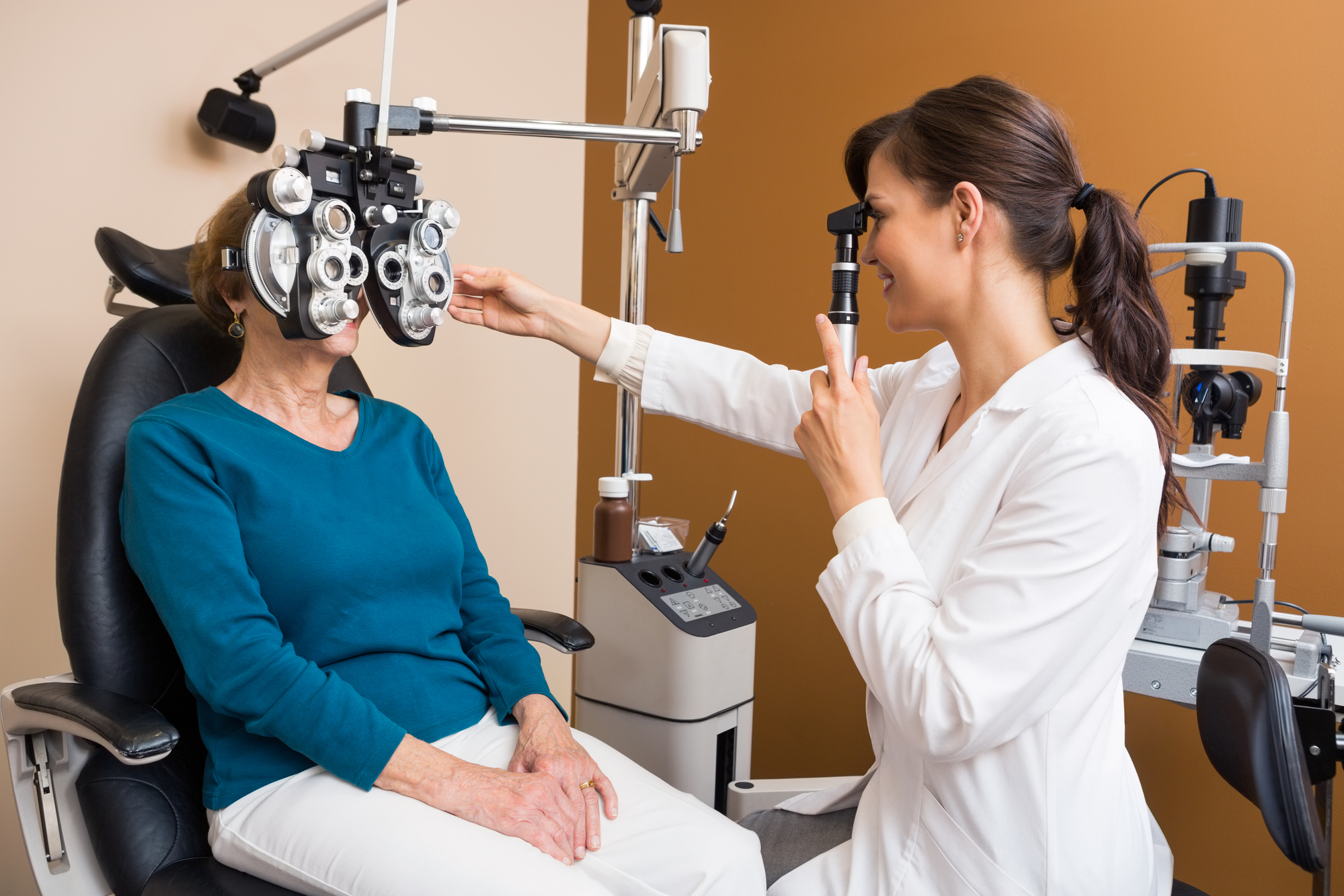 Optometrist Examining Senior Womans Eyes Using a Retinoscope Photo