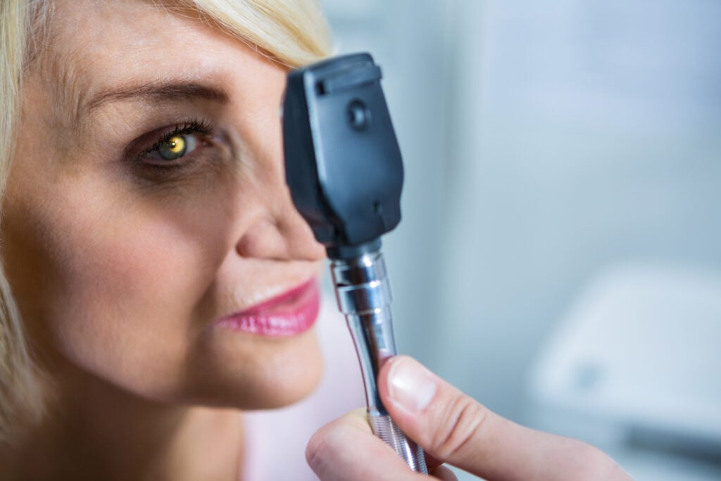 Optometrist Examining Female Patient through Ophthalmoscope Photo