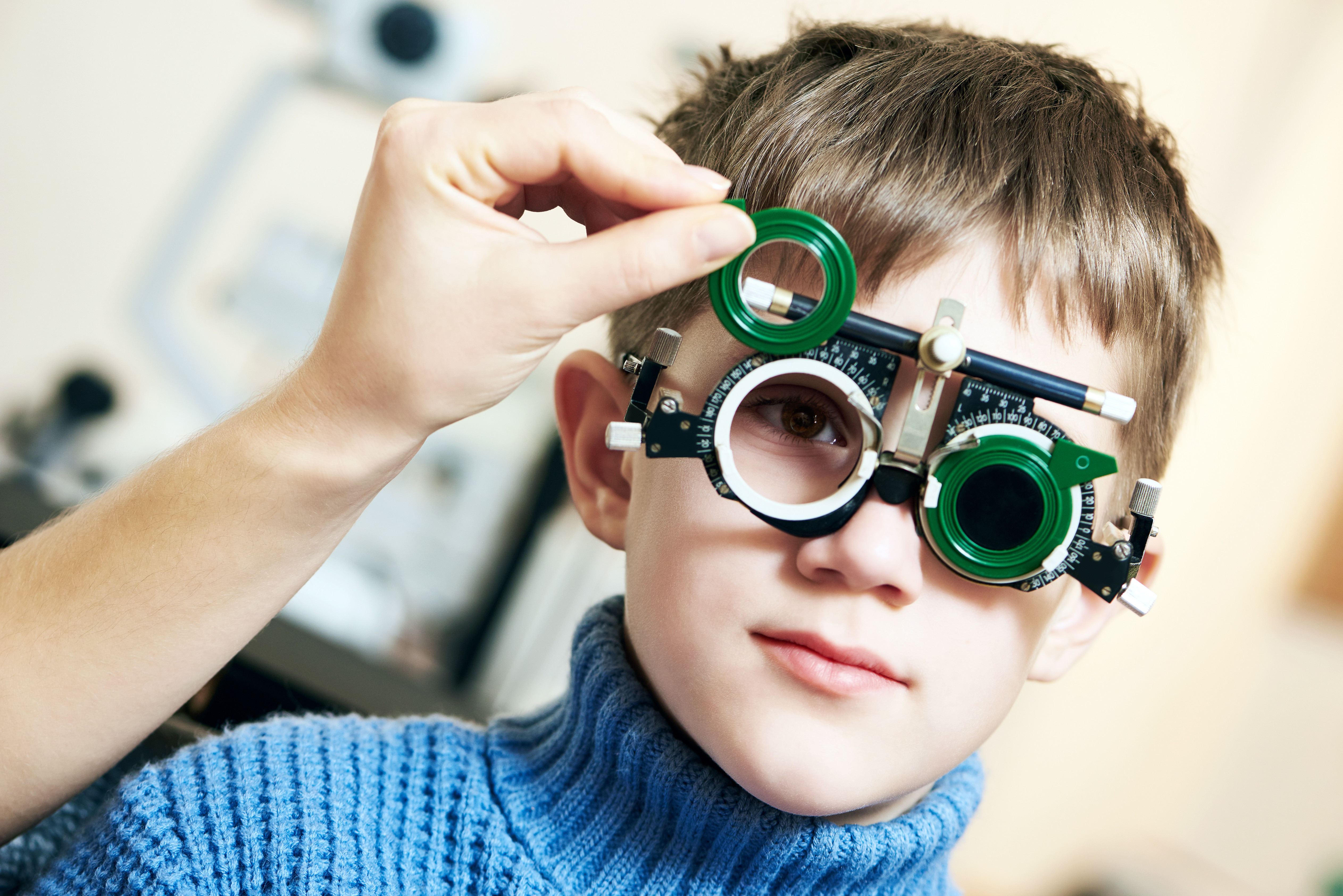 Young Boy with Phoropter During Sight Testing or Eye Examinations in Ophthalmological Clinic to Treat Amblyopia or Lazy Eye Photo