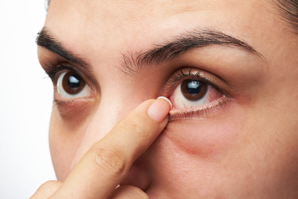 Zoomed in face of a woman touching or wiping her eye