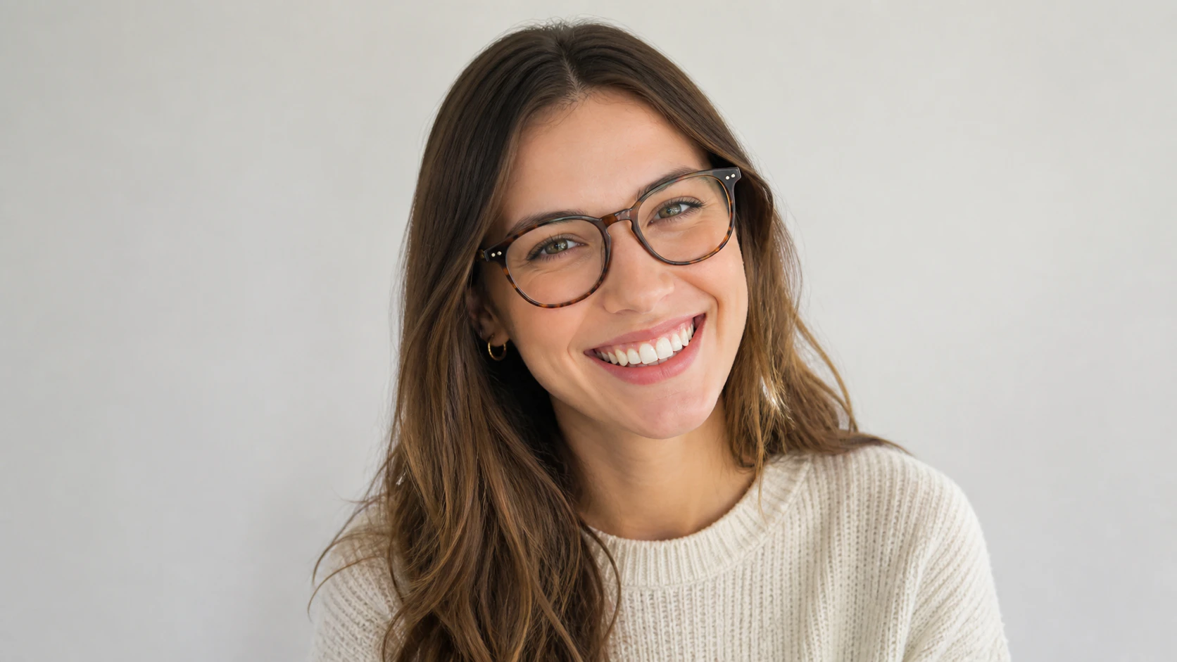 Young woman smiling widely as she wears new pair of eyeglasses