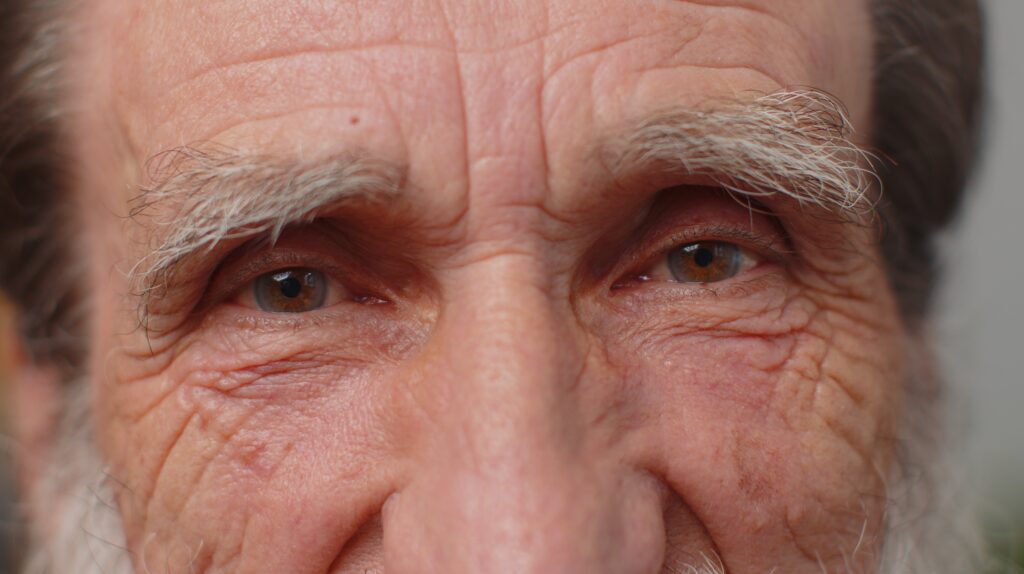 Brown Eye Color 6 47911792 extreme close up macro portrait of wrinkled face old senior beautiful mans eyes looking at camera min