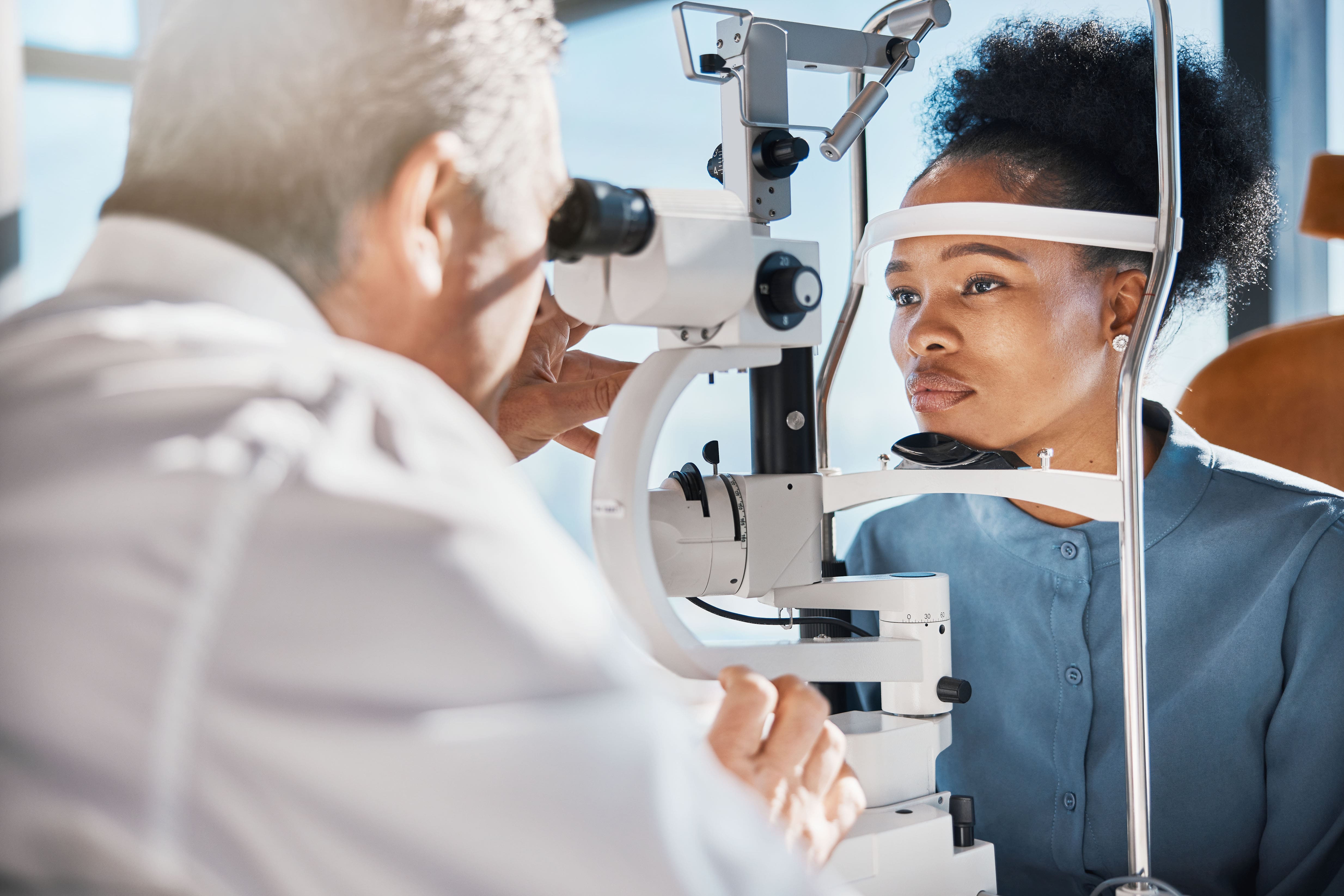 Eye exam black woman consulting with an eye doctor min
