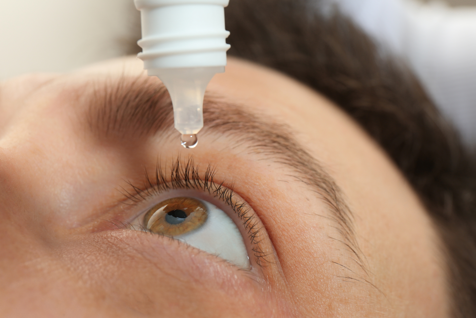 Closeup view of man using eye drops made of ofloxacin solution